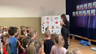 Nauczycielka pokazuje dzieciom okładkę książki