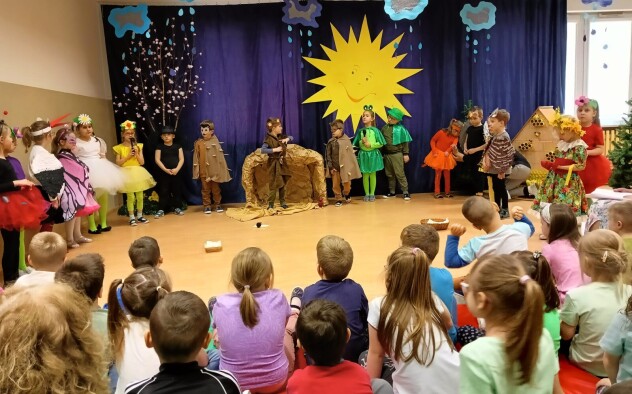 Grupa dzieci przebrana za leśne zwierzęta śpiewa piosenki na przedstawieniu z okazji pierwszego dnia wiosny