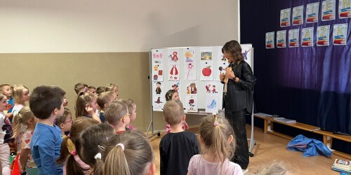 Nauczycielka pokazuje dzieciom okładkę książki